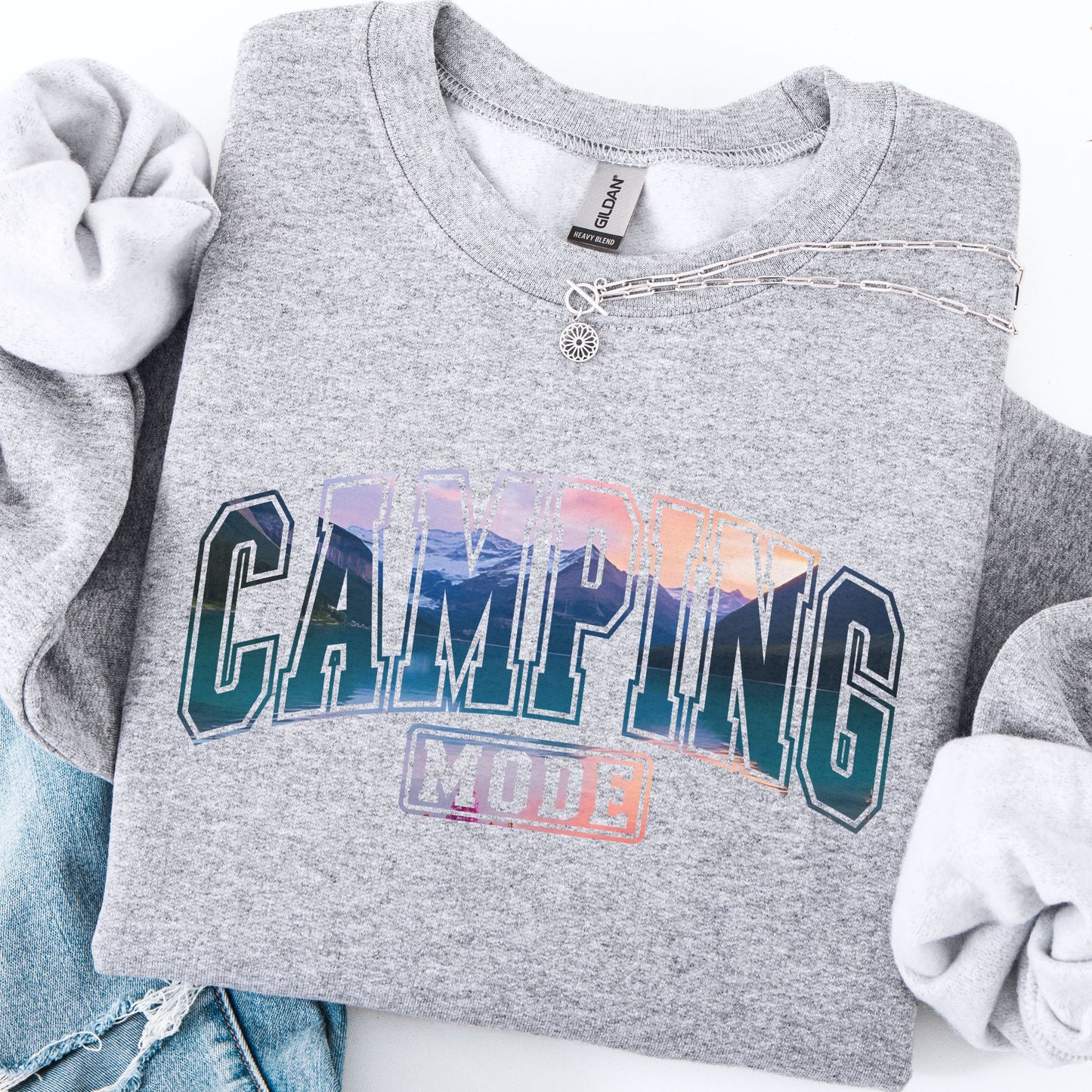 Gray sweatshirt with 'Camping Mode' text and colorful design on a white background
