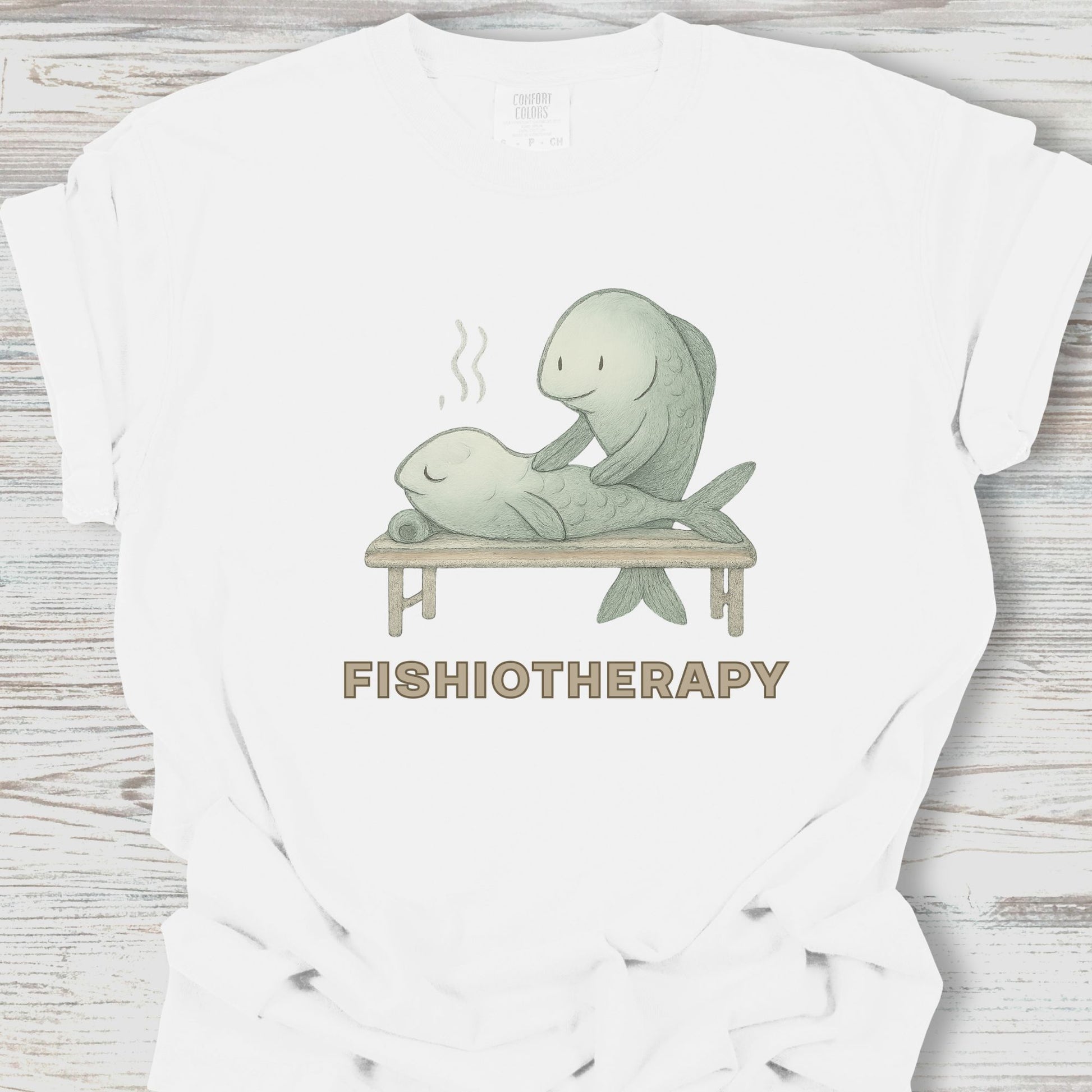 White t-shirt with 'Fishiotherapy' graphic featuring a fish giving a massage to a person on a wooden bench.