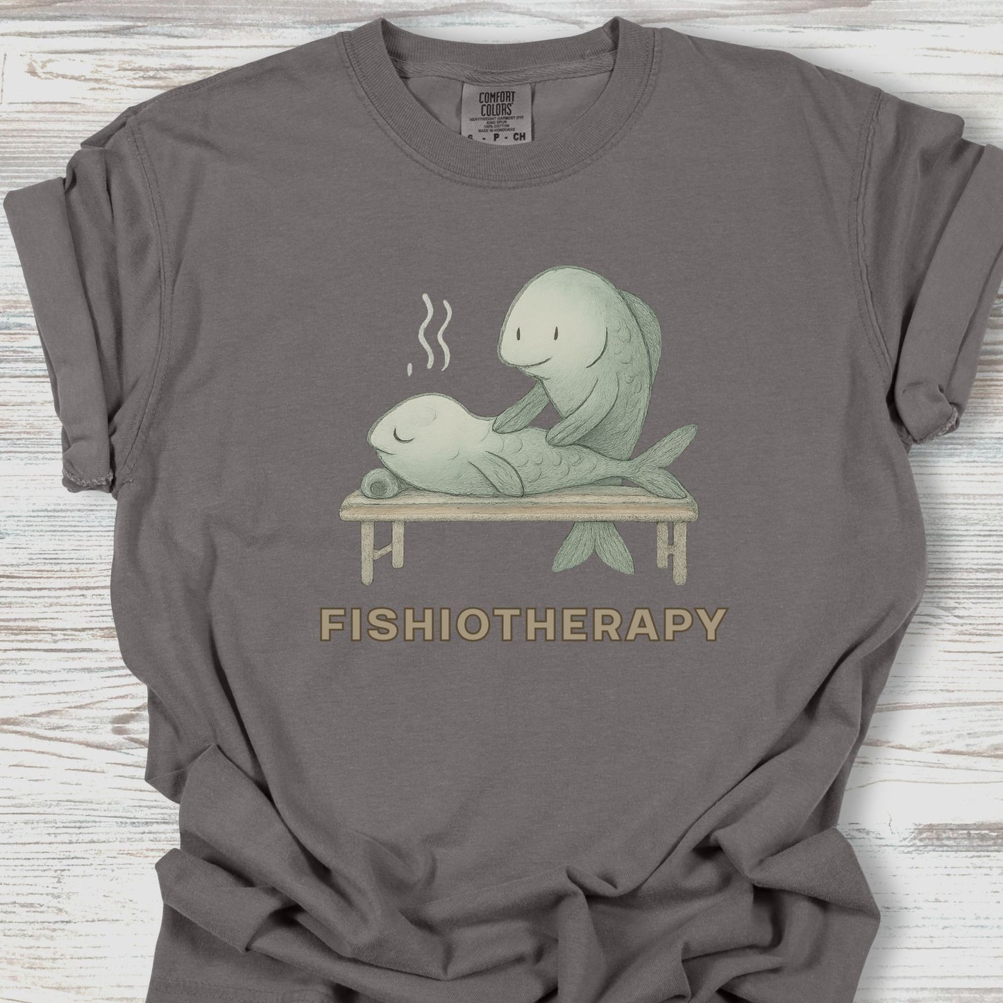 Gray t-shirt with 'Fishiotherapy' graphic on a wooden surface