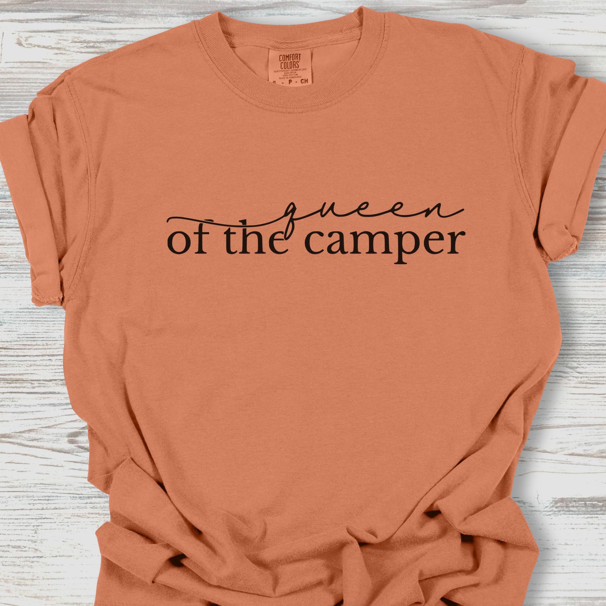 Coral t-shirt with 'Queen of the Camper' text on a wooden surface