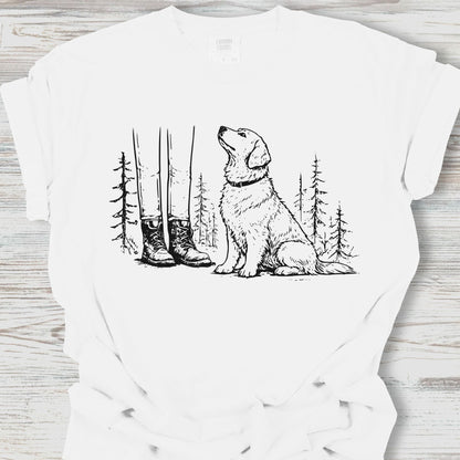 White t-shirt with a graphic of a dog, boots, and trees on a wooden surface