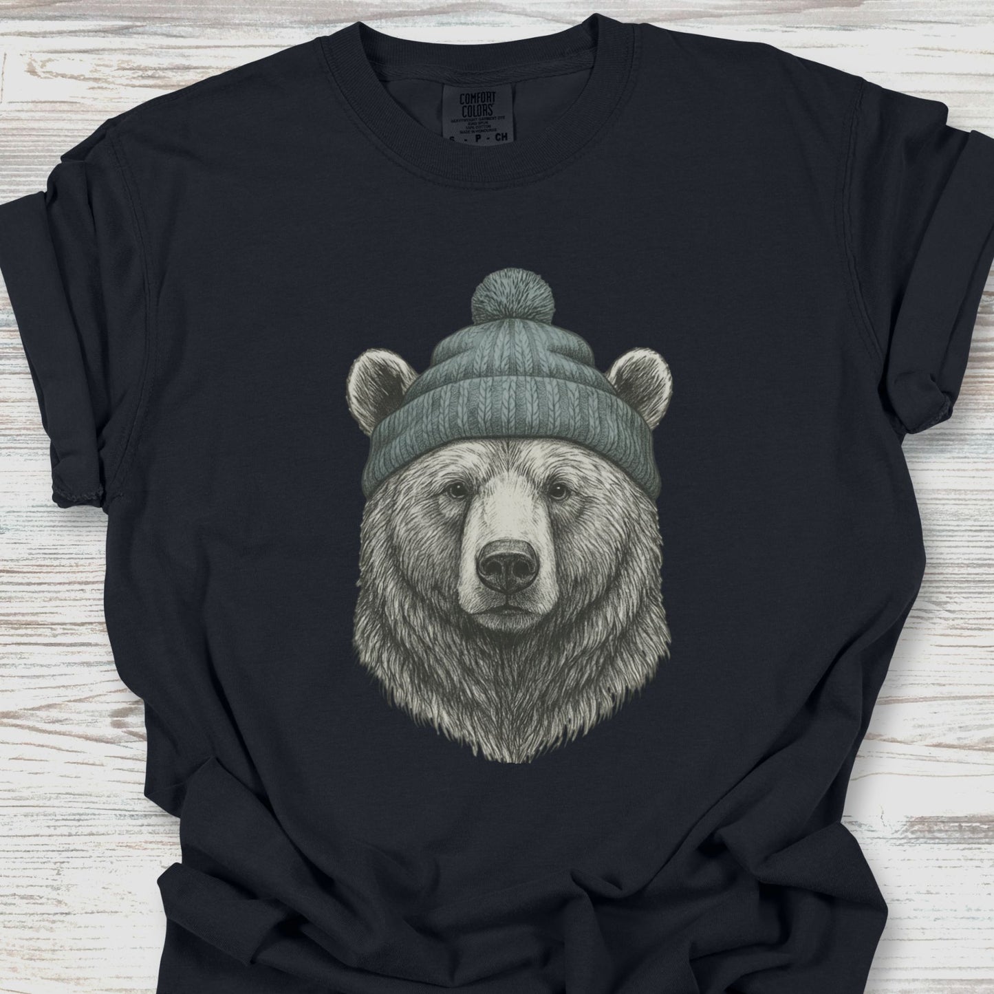 Black t-shirt with a bear wearing a beanie on a wooden surface