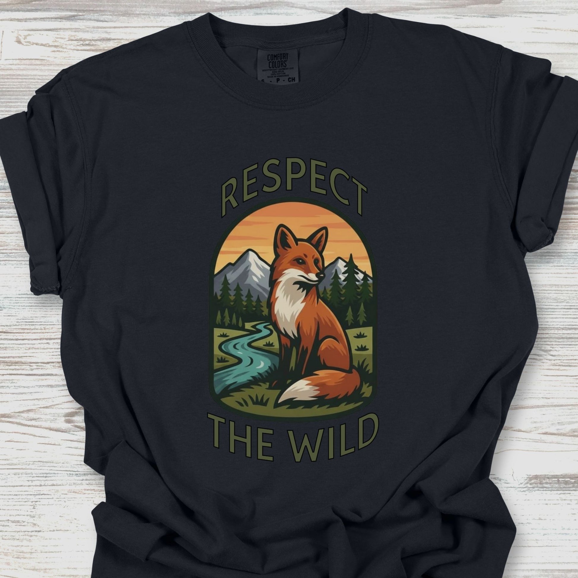 Black t-shirt with a fox graphic and 'Respect the Wild' text on a wooden surface