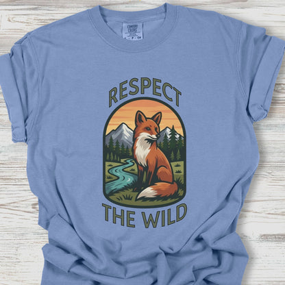 Blue t-shirt with a fox graphic and 'Respect the Wild' text on a wooden surface