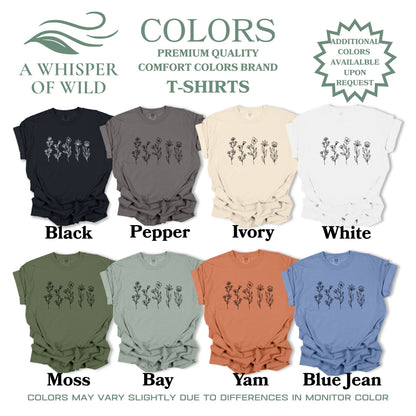 Collection of t-shirts in various colors with floral designs, branded 'A Whisper of Wild'.