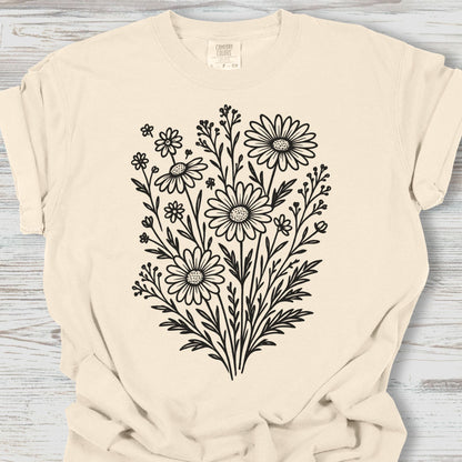 Beige t-shirt with black floral design on a wooden surface