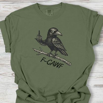 Green t-shirt with a black crow graphic and 'F-CAWF' text on a wooden surface