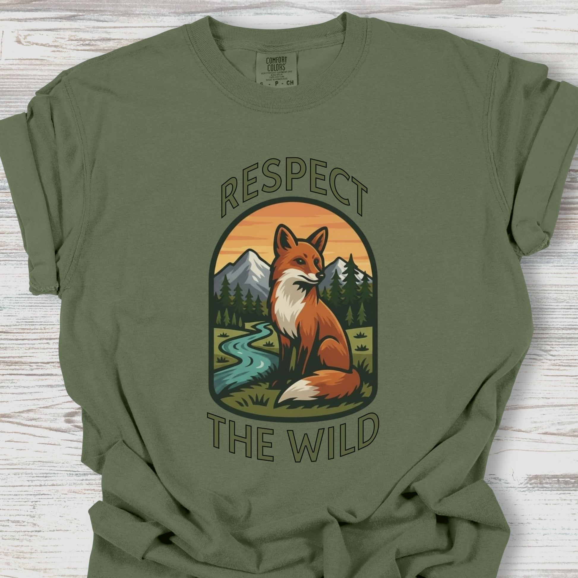 Green t-shirt with a fox graphic and 'Respect the Wild' text on a wooden surface