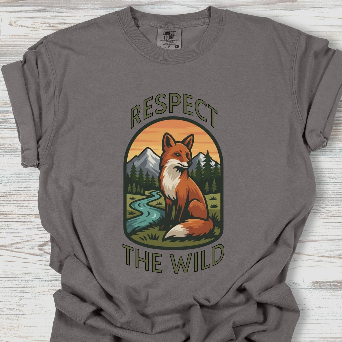 Gray t-shirt with a fox graphic and 'Respect the Wild' text on a wooden surface