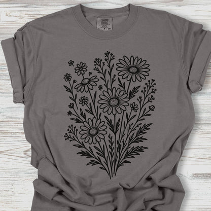 Gray t-shirt with black floral design on a wooden surface