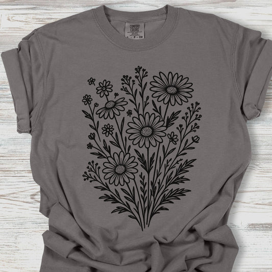 Gray t-shirt with black floral design on a wooden surface