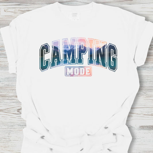 White t-shirt with 'Camping Mode' text on a wooden surface