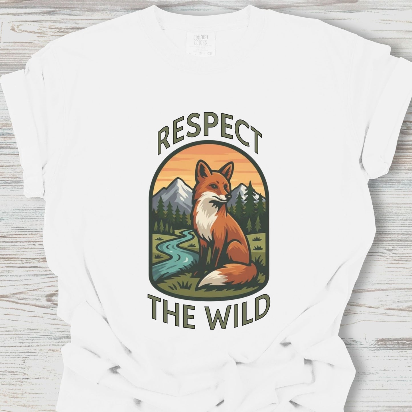 White t-shirt with a fox graphic and 'Respect the Wild' text on a wooden surface