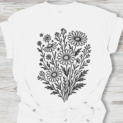White t-shirt with black floral design on a wooden surface