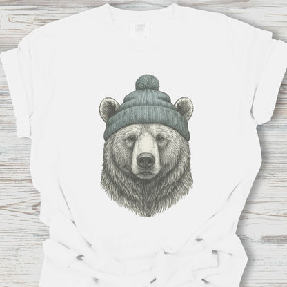 White t-shirt with a bear wearing a beanie graphic on a wooden surface