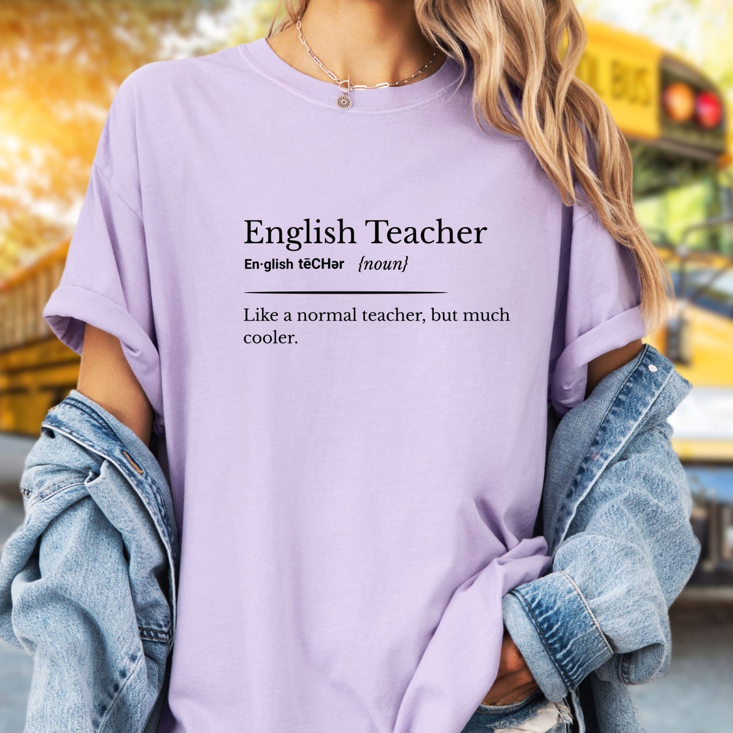 Model wears a light purple  tshirt with black lettering that is written like a dictionary definition.  It says English Teacher, En-glish TeCHer (noun), Like a normal Teacher, but much cooler.  Makes a great gift for an English Teacher