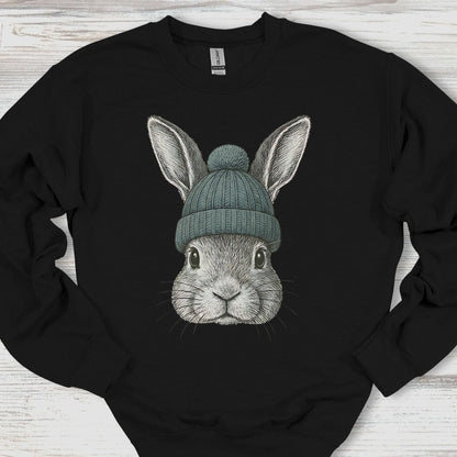 Black sweatshirt with a graphic of a rabbit wearing a green beanie on a wooden surface