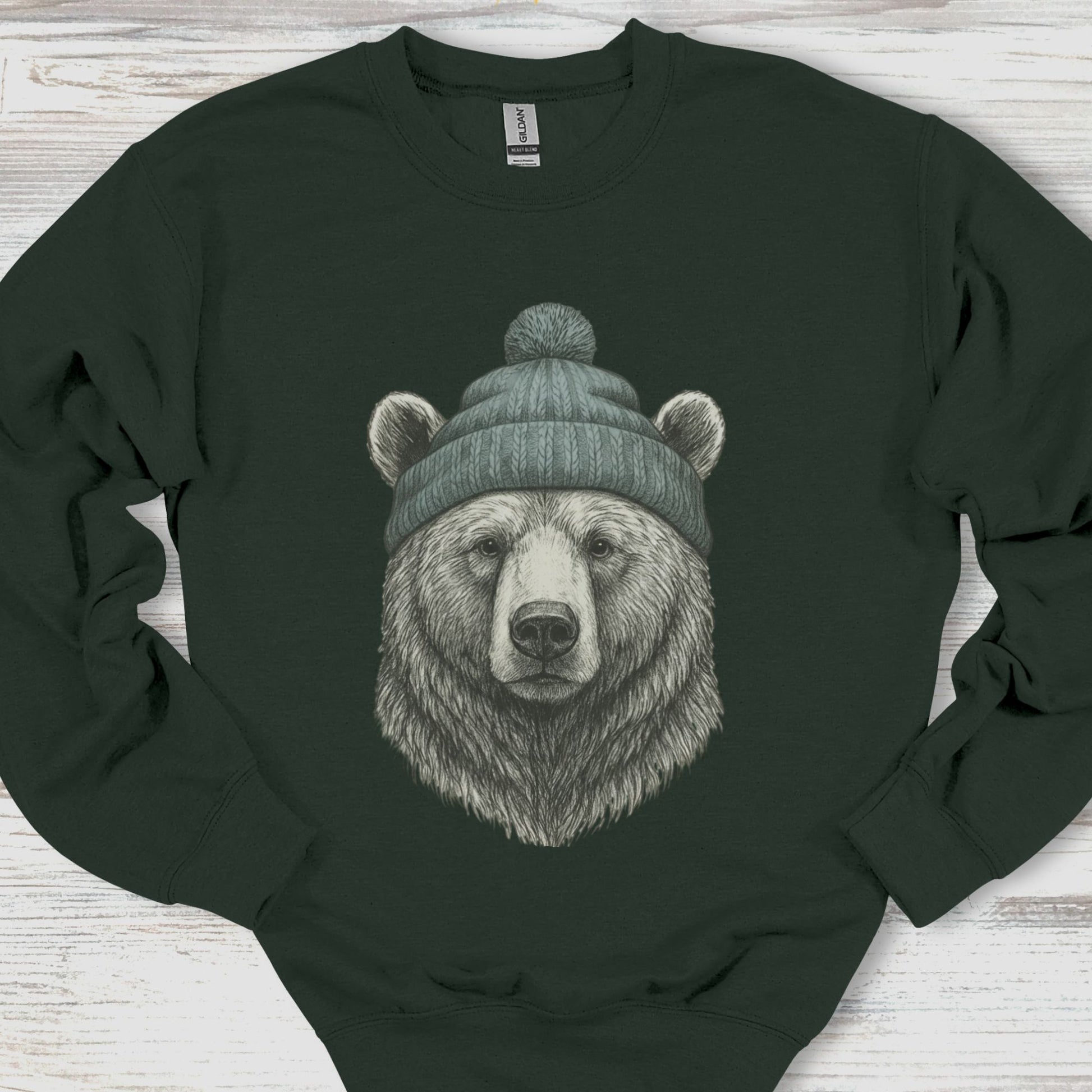 Black sweatshirt with a bear wearing a green beanie on a wooden surface