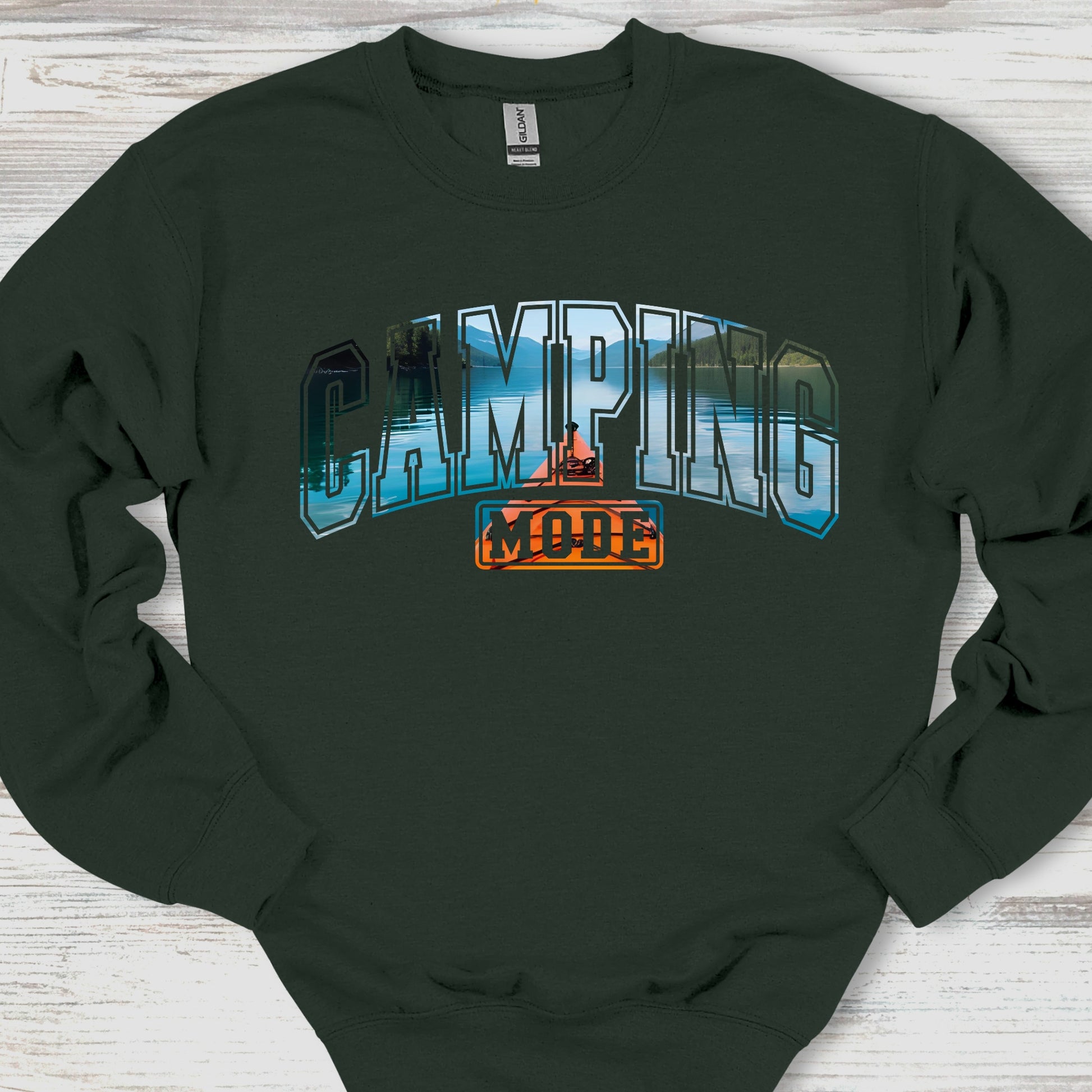 Black sweatshirt with 'Camping Mode' graphic on a wooden surface