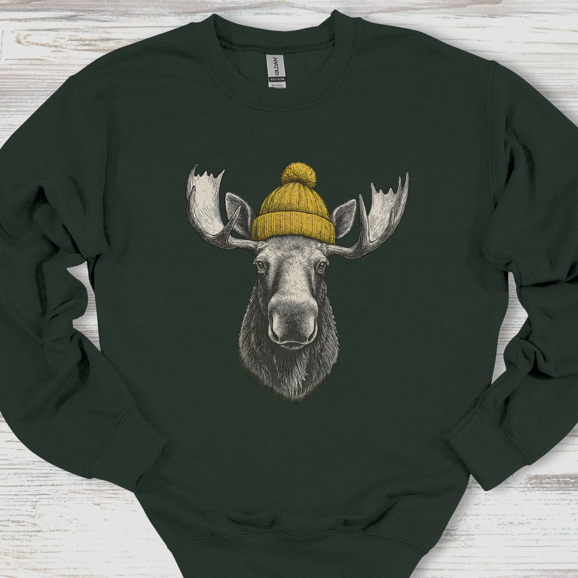 Black sweatshirt with a moose wearing a yellow beanie on a wooden surface