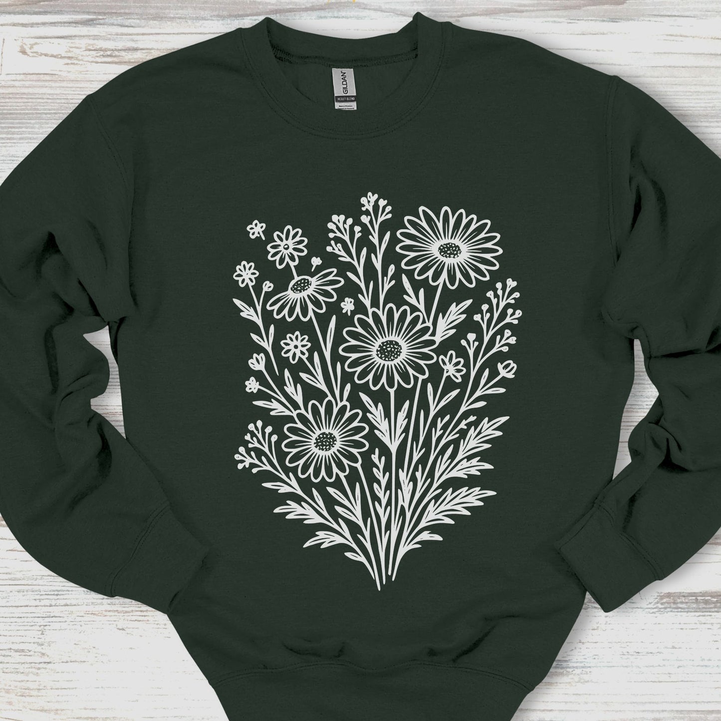 Black sweatshirt with white floral design on a wooden surface