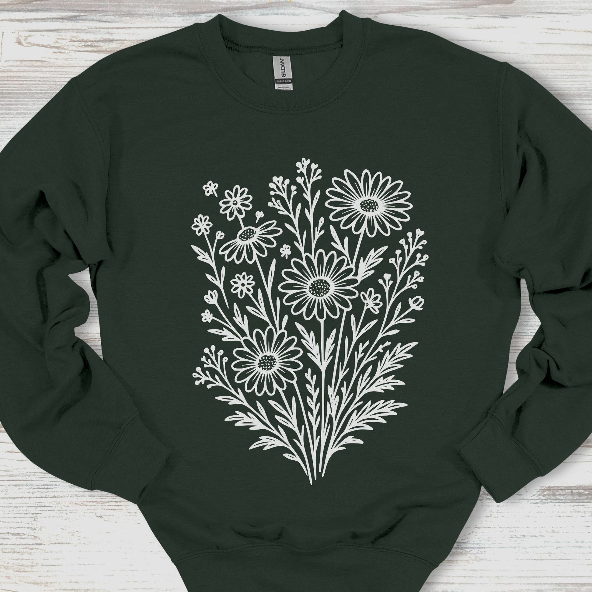 Black sweatshirt with white floral design on a wooden surface