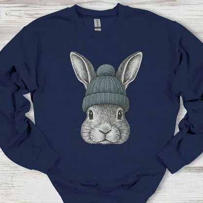 Navy blue sweatshirt with a graphic of a rabbit wearing a green beanie on a wooden surface.
