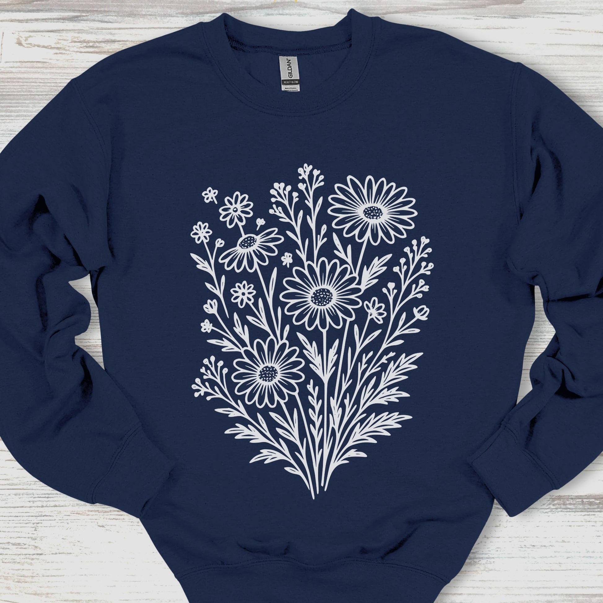 Navy blue sweatshirt with white floral design on a wooden surface