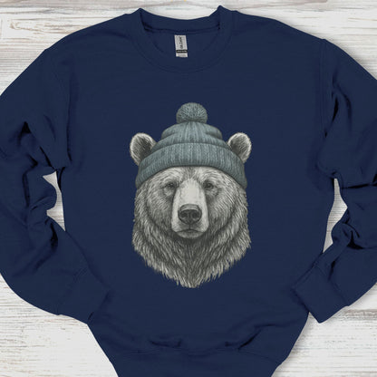 Navy blue sweatshirt with a bear wearing a beanie on a wooden surface