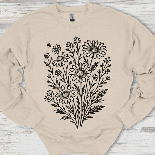 Beige sweatshirt with black floral design on a wooden surface