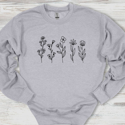 Gray sweatshirt with black floral designs on a wooden surface