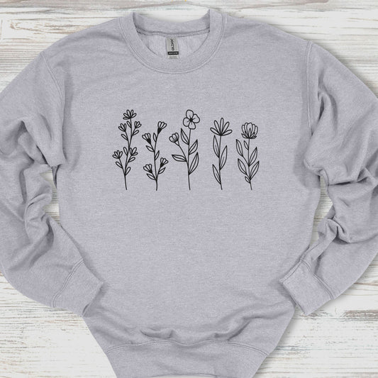 Gray sweatshirt with black floral designs on a wooden surface