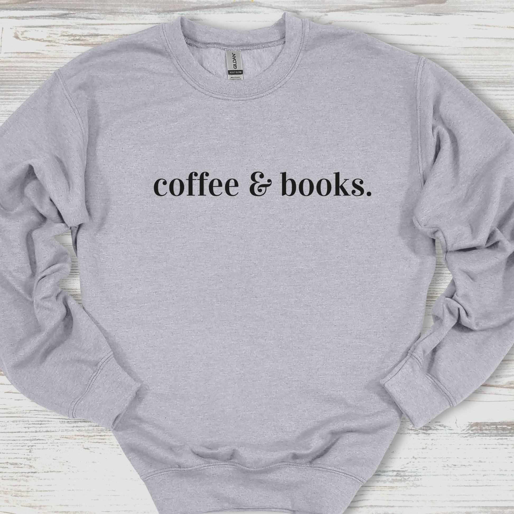 Gray sweatshirt with 'coffee & books.' text on a wooden surface