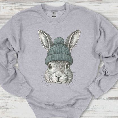 Gray sweatshirt with a graphic of a rabbit wearing a green beanie on a wooden surface