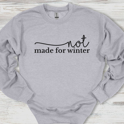 Gray sweatshirt with 'not made for winter' text on a wooden surface