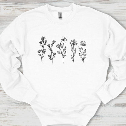 White sweatshirt with black floral patterns on a wooden surface