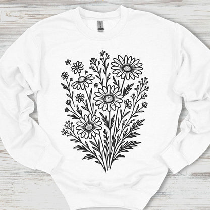 White sweatshirt with black floral design on a wooden surface