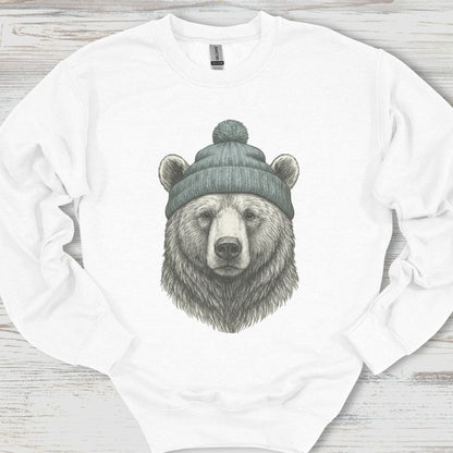 White sweatshirt with a bear wearing a beanie design on a wooden surface