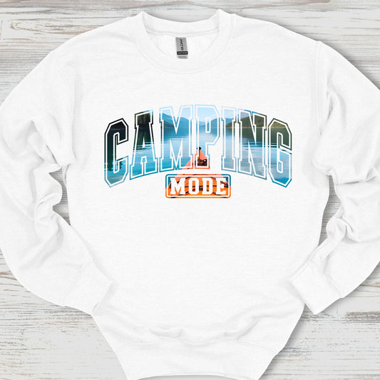 White sweatshirt with 'Camping Mode' graphic on a wooden surface